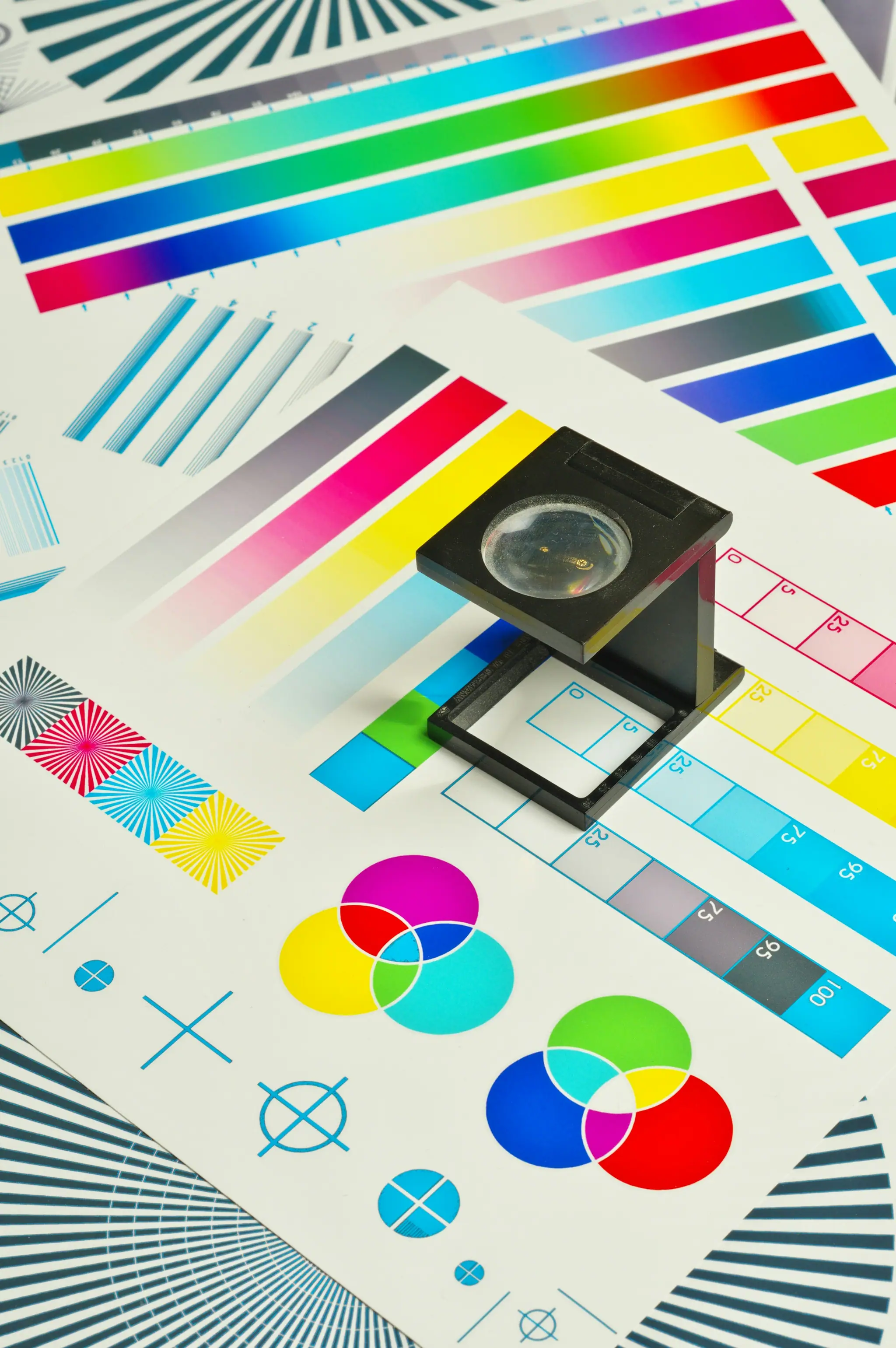Linen tester magnifier resting on a CMYK colour calibration chart