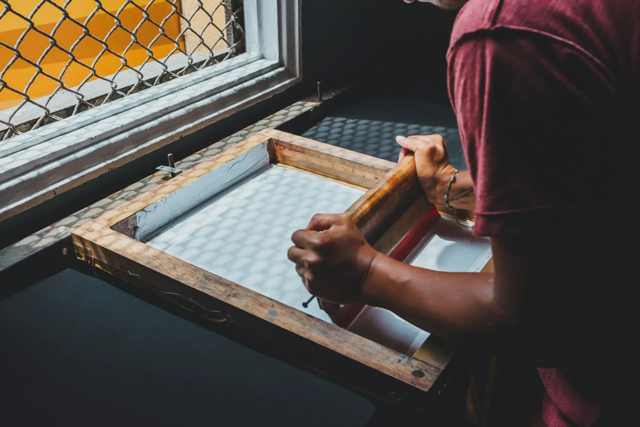 Printer holding a screen-printing frame by a window